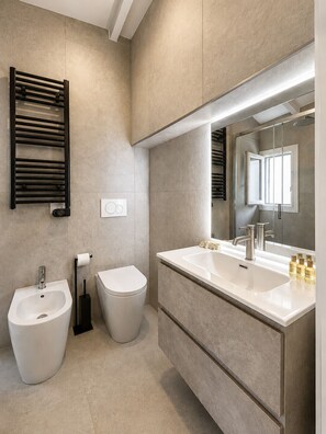 A modern bathroom with a bidet, toilet, and a large mirror. - Pitti Suite 1 (Florence)