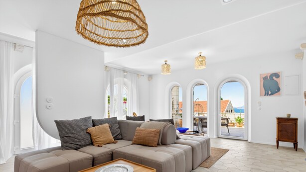 Una sala de estar moderna con un sofá modular, una mesa de centro de madera y un amplio ventanal con vistas.