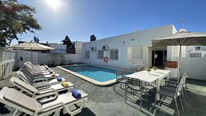 A poolside area with lounge chairs, a table, and umbrellas. - Branca | Private Pool | 12 Pax | Albufeira (Albufeira)