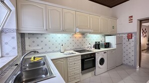 A kitchen with white cabinets, a stainless steel sink, a microwave, a coffee maker, and a washing machine. - Branca | Private Pool | 12 Pax | Albufeira (Albufeira)