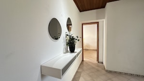 A hallway with a white console table, a potted plant, and two wall-mounted mirrors. - Rosa | Private Pool | Sleeps 8 | Albufeira (Albufeira)