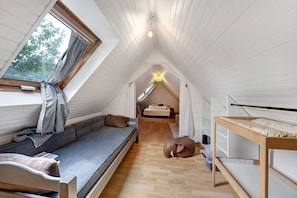 A compact room with a loft bed, a bench, and a small table.