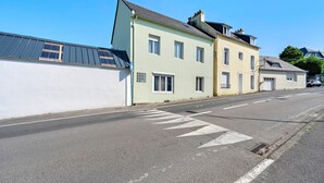 A street with buildings, a pedestrian crossing, and a parked car. - Family Home in Morgat, Enclosed Garden, 2 Minutes from the Beach (Crozon)