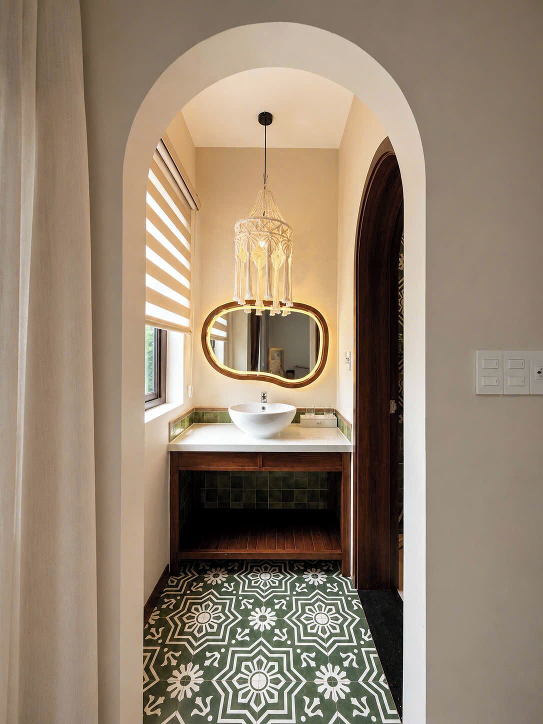 A narrow hallway with a vanity, a mirror, and a chandelier.