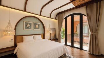 A bedroom with a bed, two wall-mounted lamps, a starfish and shell decoration, and a view of the outside balcony.