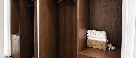 Un armario con puertas de madera, una percha y una cesta de mimbre sobre un tocador.