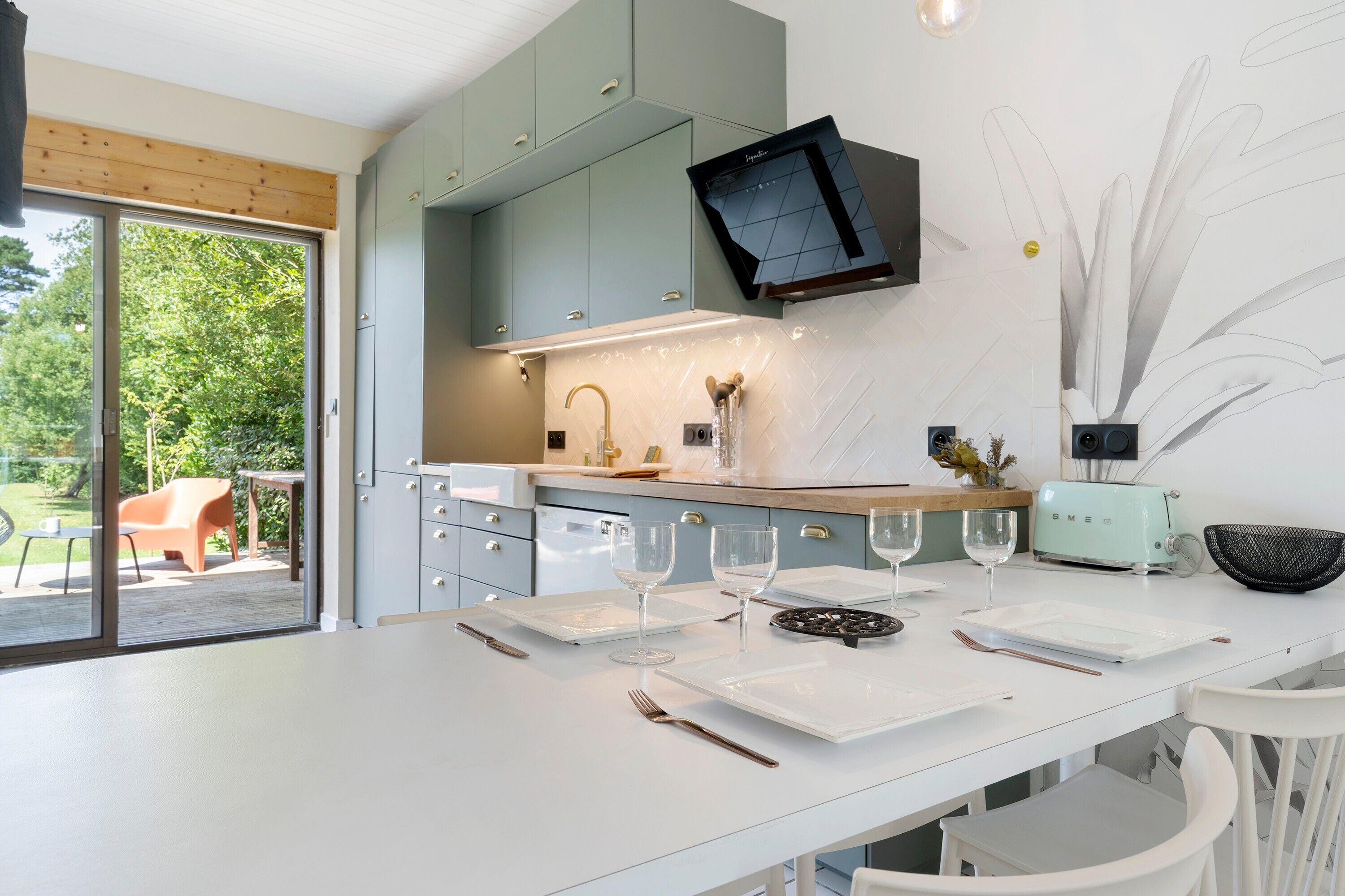 Una cucina moderna con zona pranzo, una televisione a parete e vista sull'esterno.