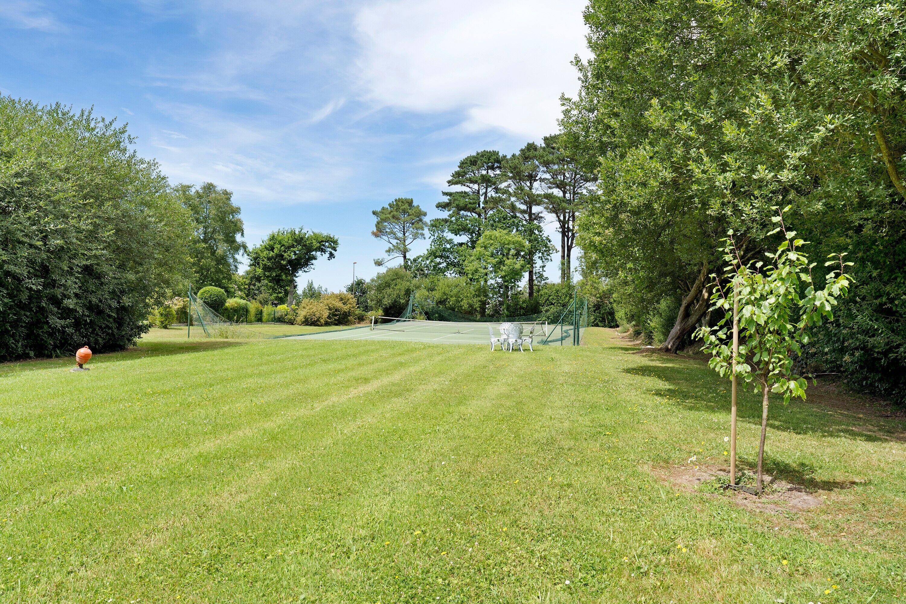 A well-maintained grassy area with trees and a clear sky.