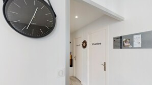 A hallway with a clock, a door labeled 'Salle d'Od,' and a bulletin board with notices. - Sea View in the Heart of Morgat (Crozon)