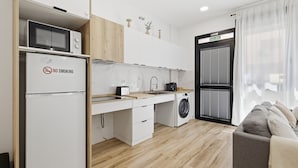 Eine kompakte Küche mit Mikrowelle, Toaster, Spüle und Waschmaschine.