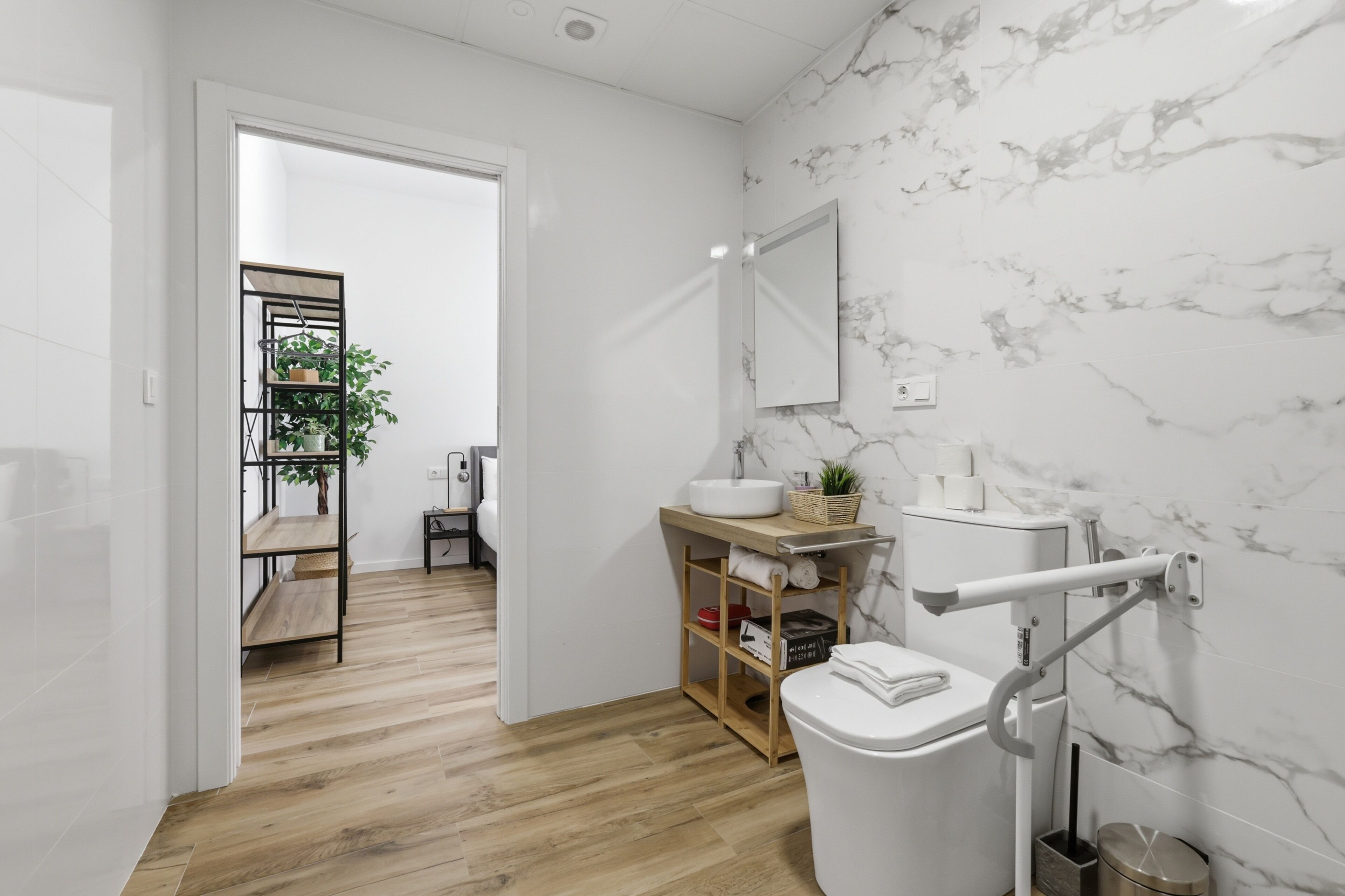 Ein modernes Badezimmer mit Toilette, Waschbecken und Marmorwand.