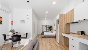 Ein gemütlicher Wohnraum mit Küchenzeile, Essbereich und Schlafzimmer.