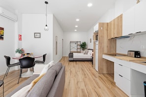 A compact living space with a kitchenette, a dining area, and a bedroom.