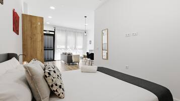 Una habitación de hotel moderna con una cama grande, una puerta de madera, un escritorio y una silla.