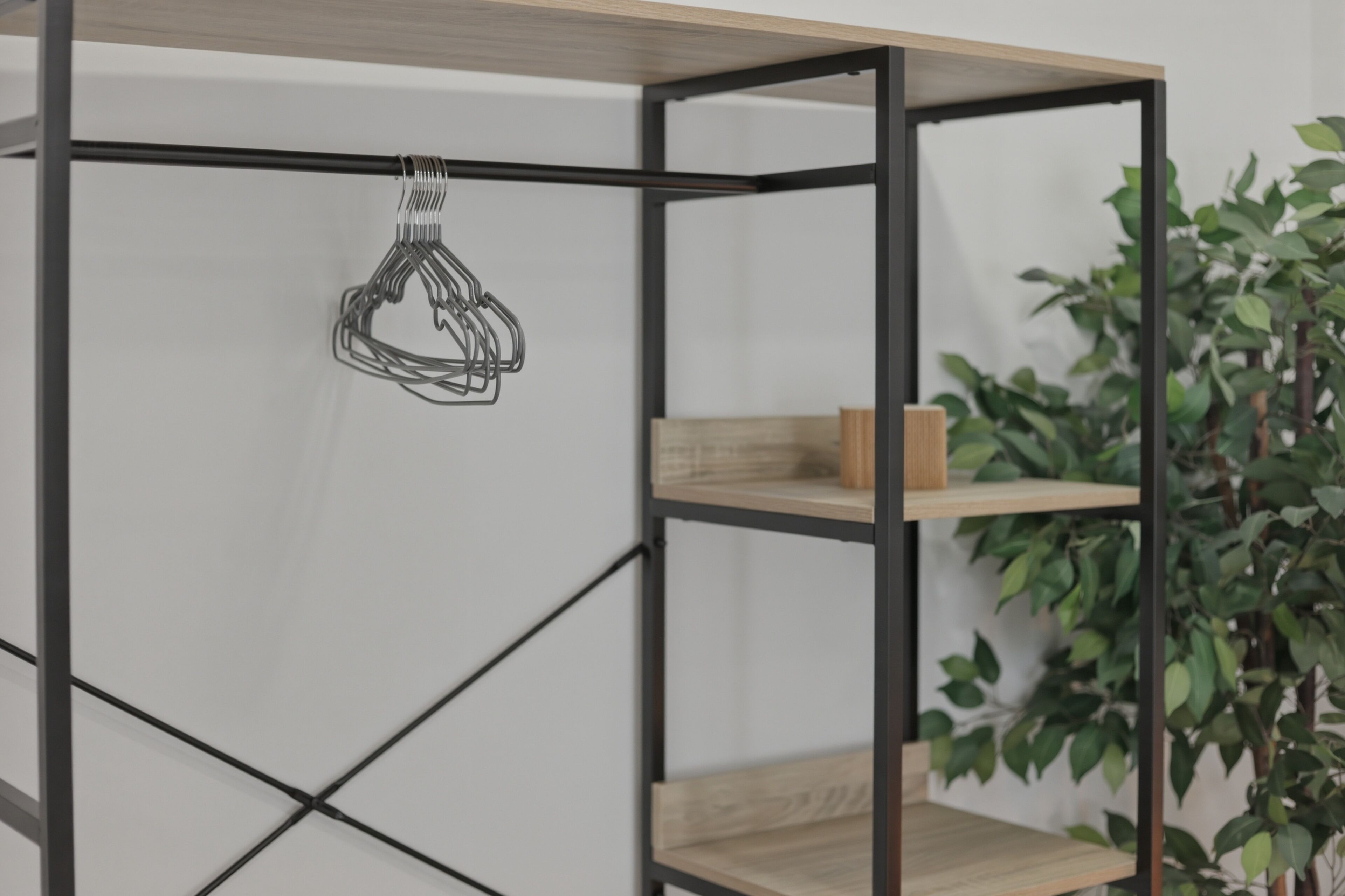A metal-framed shelving unit with a hanging light fixture and a potted plant.