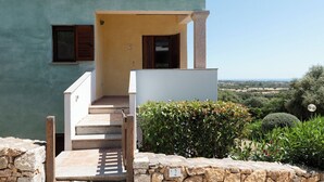 A house with a stone wall, a set of stairs leading to a porch, and a view of the countryside. - Casa Luna e Sole by Wonderful Italy (Maiorca)