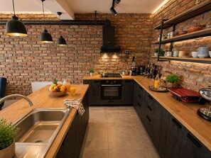 A kitchen with a brick wall, wooden countertop, stainless steel sink, and modern appliances. - Luxury Hillside Villa with Pool, Terraces & Stunning Views (Gorno Sonje)