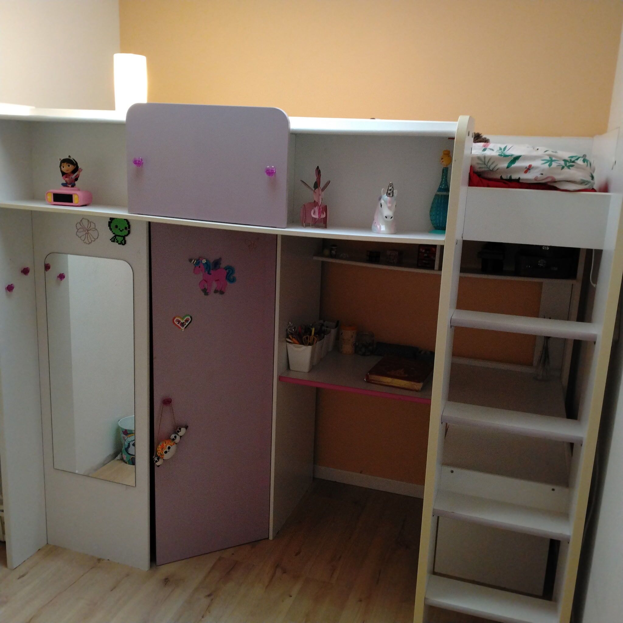 A child's bedroom with a bunk bed, a desk, and various decorations.