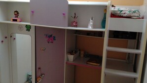 Un dormitorio infantil con literas, un escritorio y varias decoraciones.