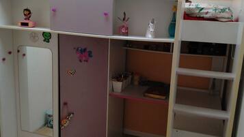 A child's bedroom with a bunk bed, a desk, and various decorations.