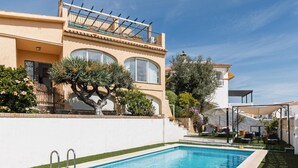 Et toetagers hus med swimmingpool, balkon og have.