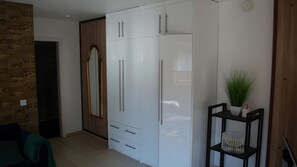 A room with a wardrobe, a mirror, a potted plant, and a small table. - Apartment in Architect’s House with Private Terrace, Garden, and Wi-Fi (Reken)