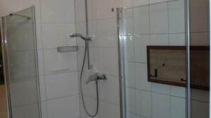 A glass-enclosed shower with a handheld showerhead and a wall-mounted faucet. - Apartment in Architect’s House with Private Terrace, Garden, and Wi-Fi (Reken)