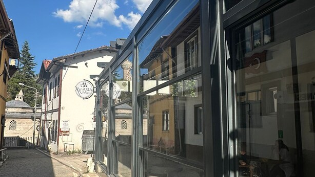 A street view with a building featuring large glass windows and a sign that reads 'AASIA.' - Ay-Asia Suit (Amasya)