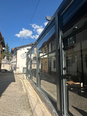A street view with a building featuring large glass windows and a sign that reads 'AASIA.'