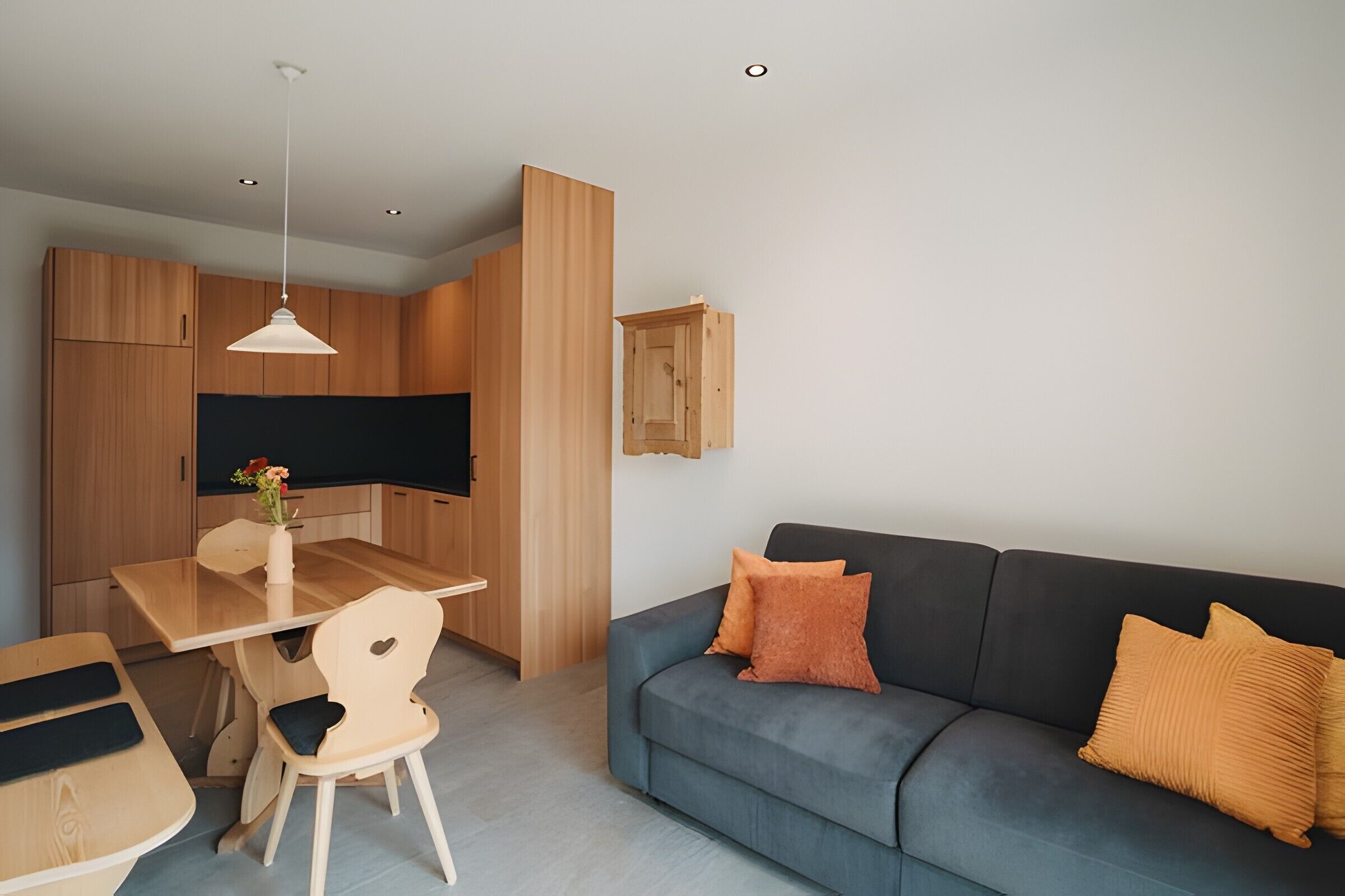 A modern living space with a dining area, a sofa, and a television.