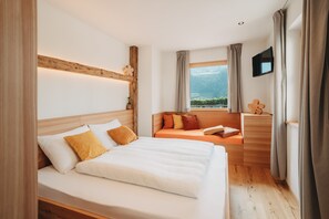 Habitación de hotel con una cama grande, un sofá, un televisor y una ventana con vistas.