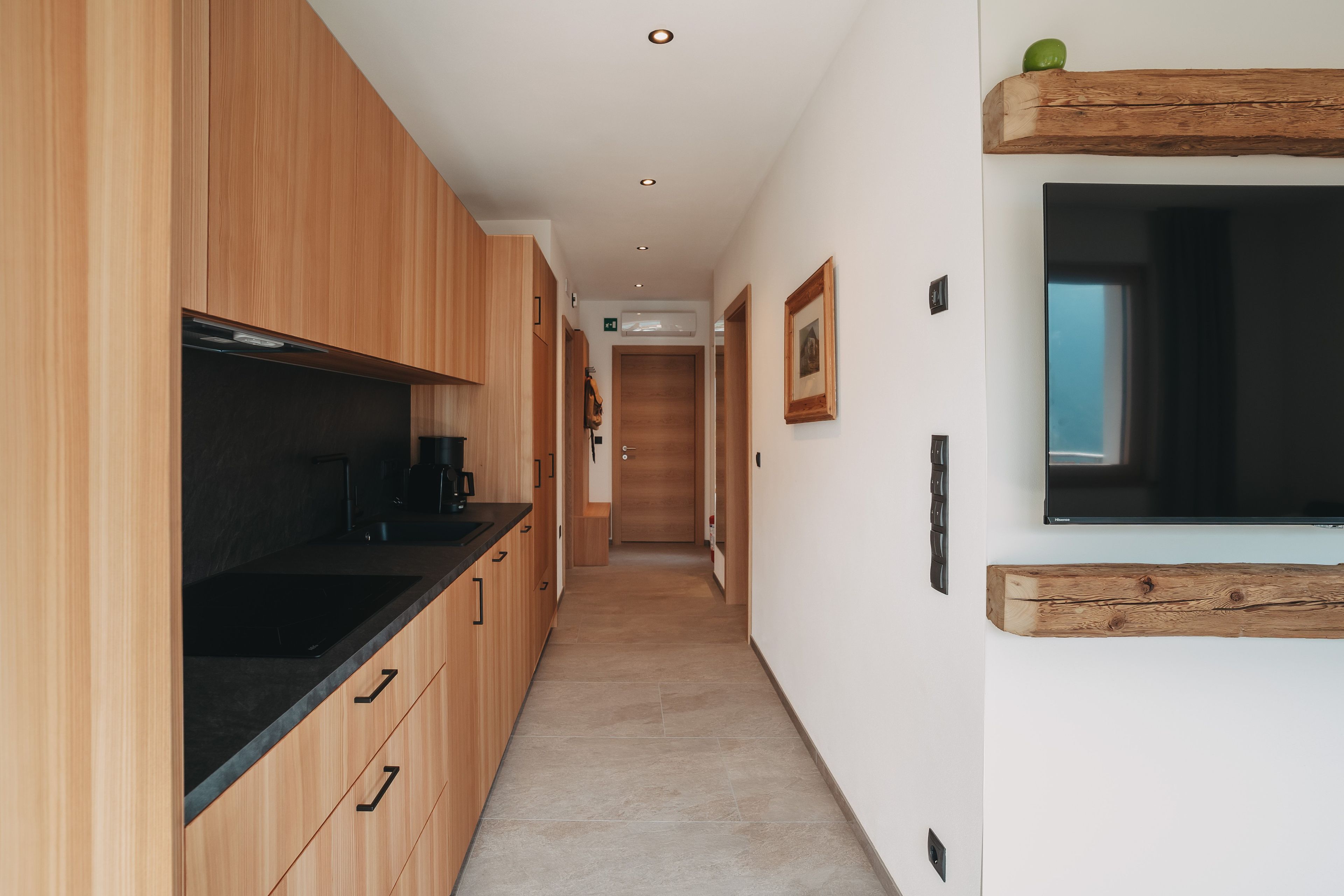 Eine moderne Küche mit Holzschränken und einer schwarzen Arbeitsplatte.