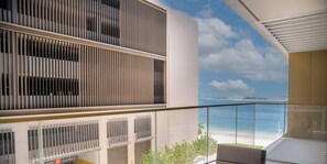 Ein modernes Gebäude mit einem Balkon mit Blick auf einen Strand.