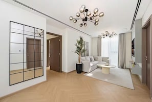Una sala de estar moderna con sofá, una mesita de centro, una planta en maceta y una lámpara decorativa en el techo.