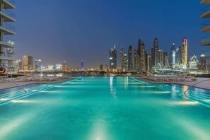 A swimming pool with a city skyline in the background. - Sea-View 1BR + Private Beach, Beach Mansion (Dubai)