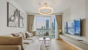 Un salon moderne avec un canapé, un téléviseur et une vue sur la ville.