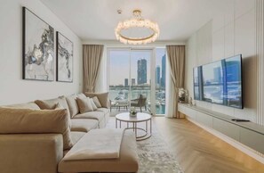 Un salon moderne avec un canapé, un téléviseur et une vue sur la ville.