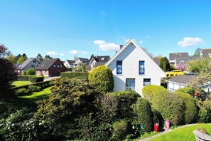A residential area with houses, well-maintained gardens, and a clear blue sky. - House Wendt Apartment 01 (Timmendorfer Strand)