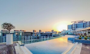 Ein modernes Hotel mit Swimmingpool, Glasgeländern und zeitgenössischer Architektur.