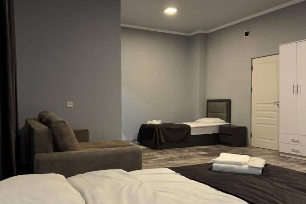 Una habitación de hotel con cama, sofá, escritorio y armario.