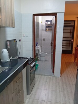 Uma cozinha compacta com fogão a gás, cafeteira e pia.