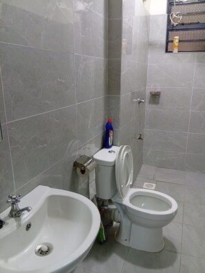 Um banheiro com pia, vaso sanitário e bidê.
