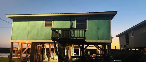 Ein zweigeschossiges Haus mit Balkon, Veranda und einer kleinen angebauten Garage.