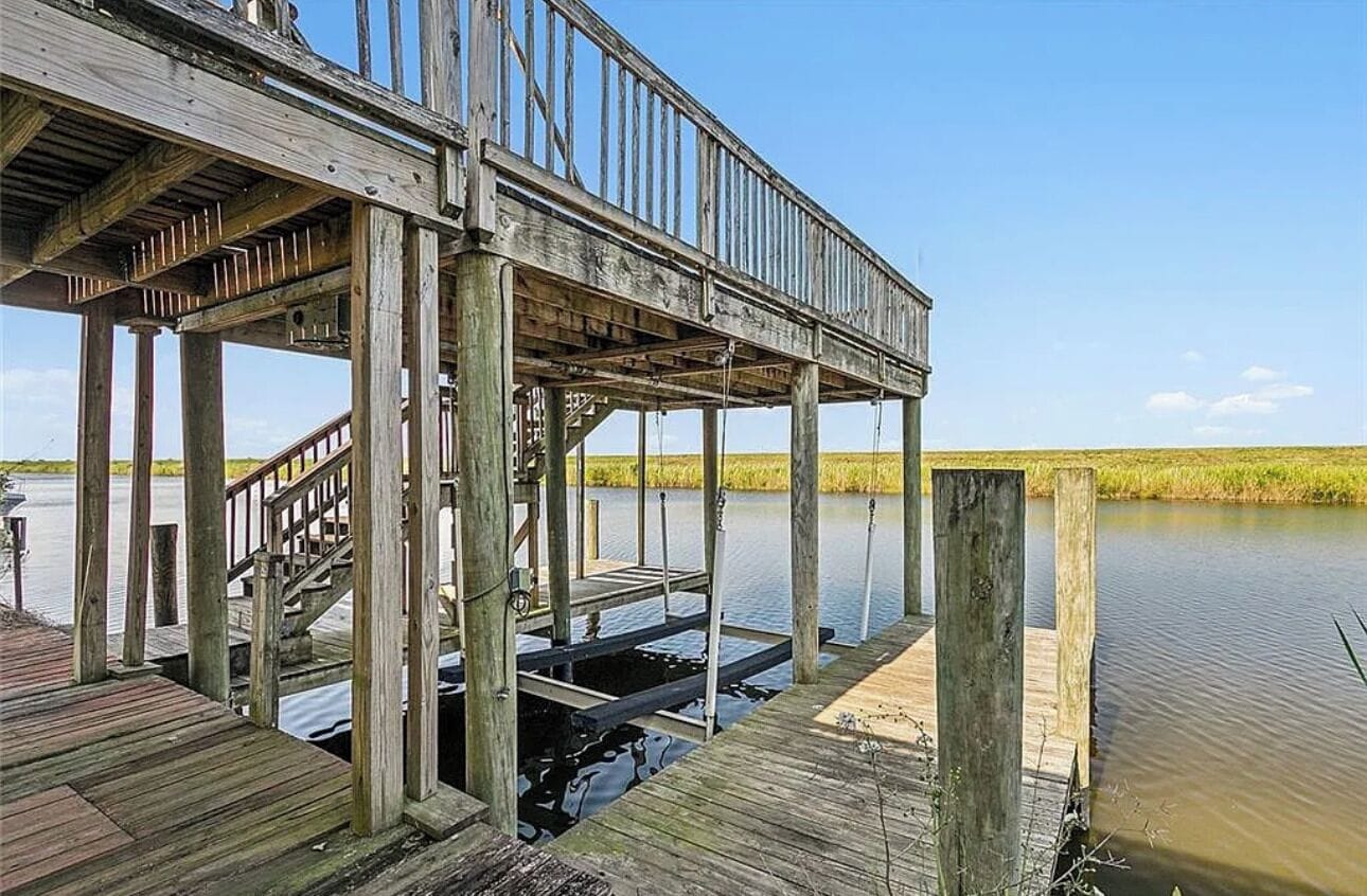 A wooden pier extending over water with a staircase leading up to a platform.