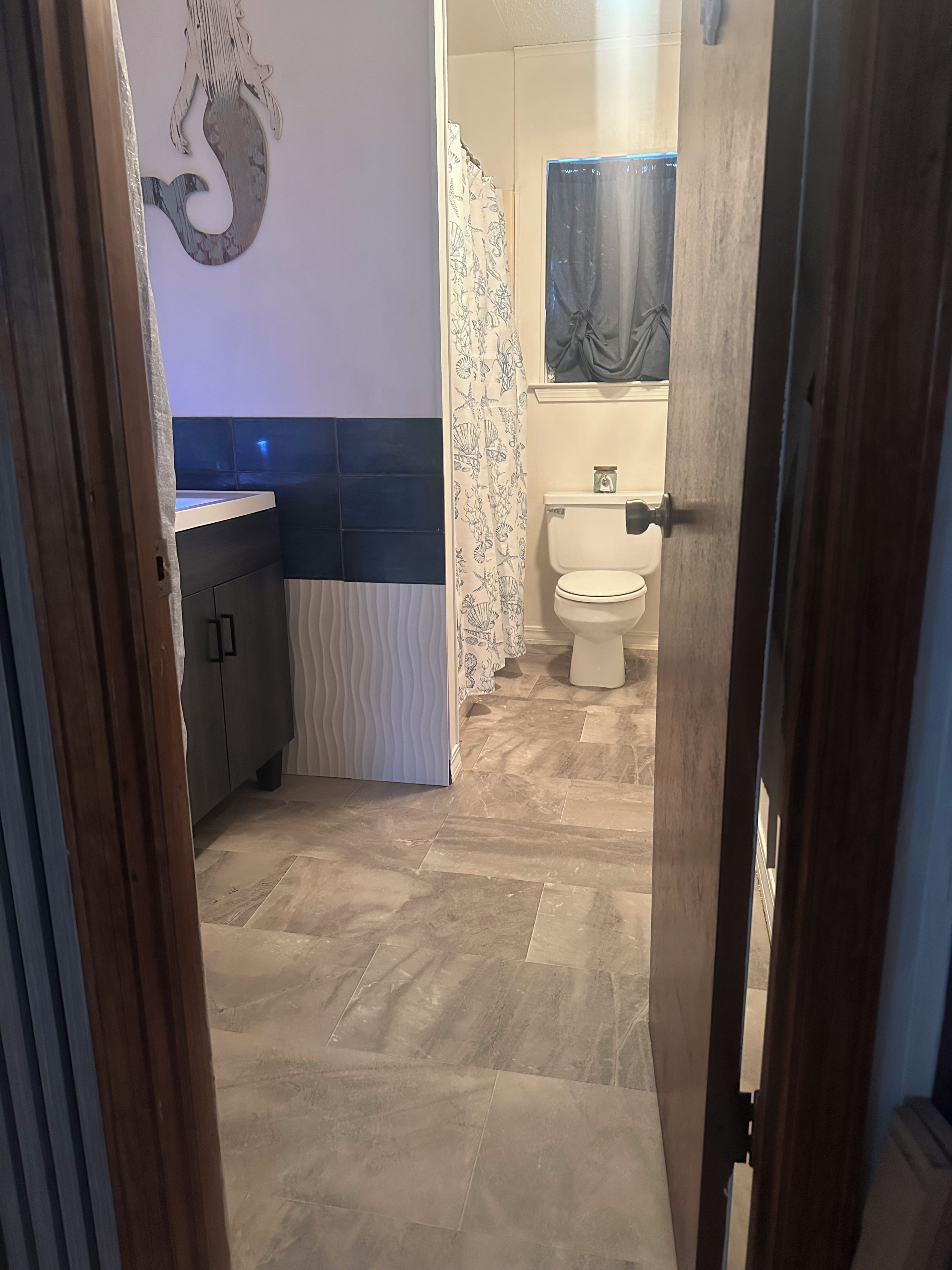 Une salle de bain comprenant des toilettes, un lavabo et un espace douche.