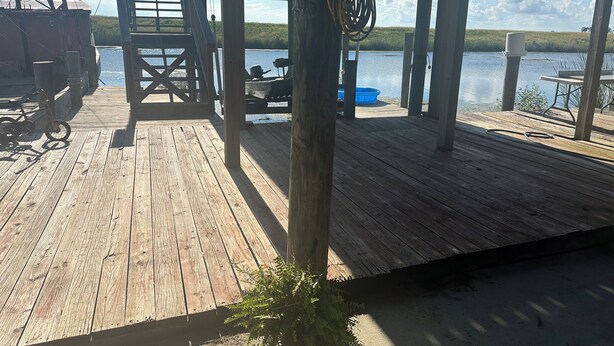 A wooden dock with a ladder, a blue container, and a table. - WELCOME to Pirates Harbor! Crab, fish & relax. Rare private boat launch  & hoist (Slidell)