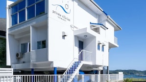 A modern two-story building with a sign that reads 'private villa kai kumano.'