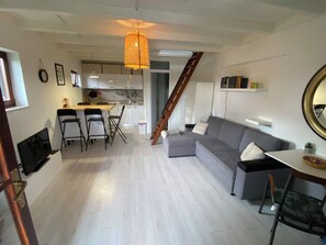 A modern living space with a dining area, kitchen, and a staircase leading to an upper level. - Mreznica - Zelena oaza I (Generalski Stol)