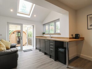 A modern kitchen with a skylight, a wooden deck, and a sliding glass door leading to an outdoor area. - The Kingfisher Falls (Melton Mowbray)