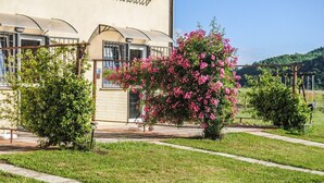 A building with a garden area, a pergola, and a pathway. - Houses in Stratola - Apartment 2 (Montella)
